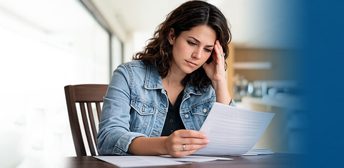 A woman reviewing paperwork at home